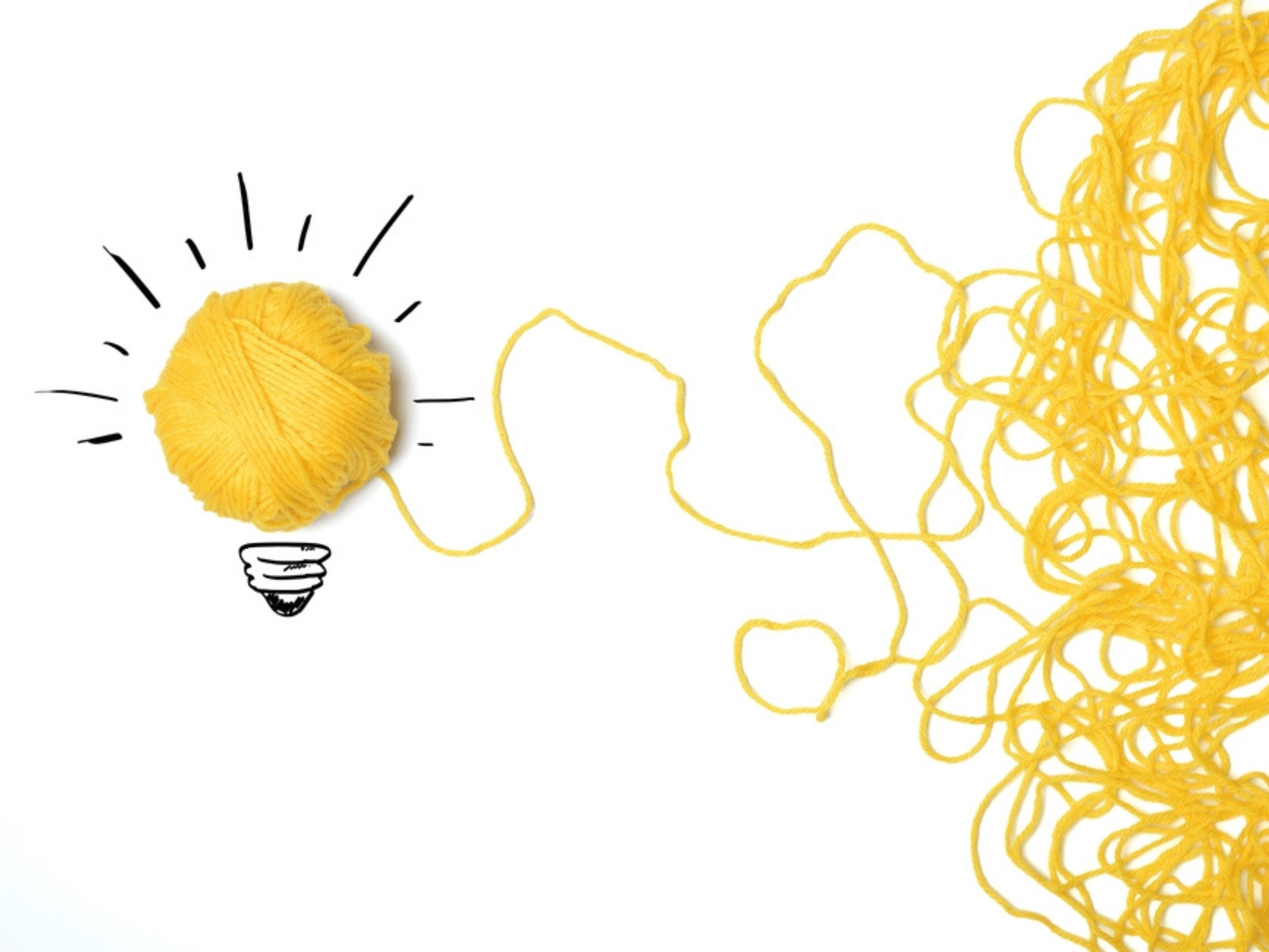 Concept of concise, powerful content is symbolized by tidy ball of yellow yarn made from mass of loose yarn